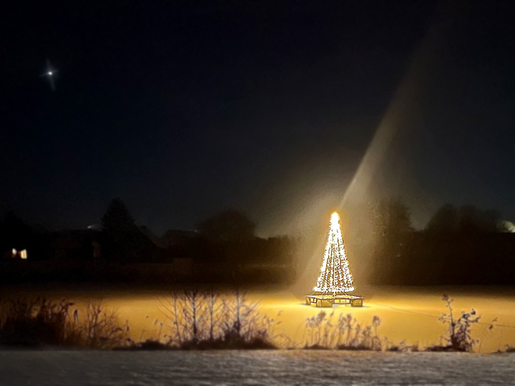 Ein künstlicher Weihnachtsbaum aus Lichterketten im Schnee-
