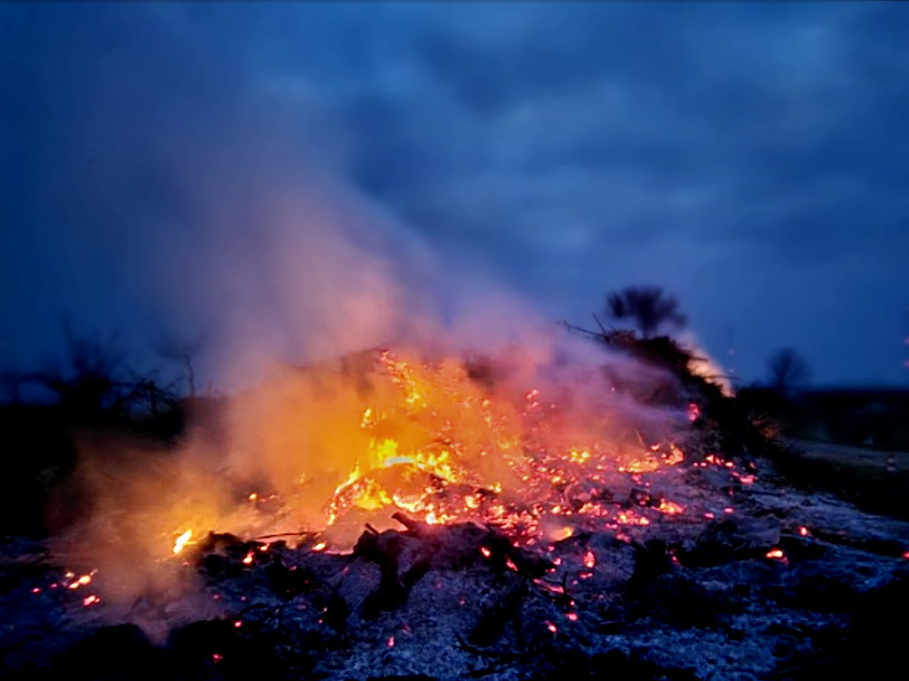 Ein brennendes Osterfeuer in beginnender Dämmerung